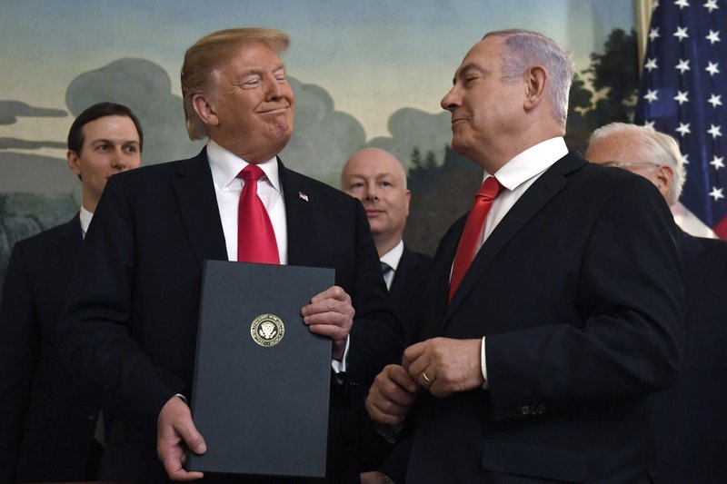 FILE - In this Monday, March 25, 2019 file photo, President Donald Trump smiles at Israeli Prime Minister Benjamin Netanyahu, right, after signing a proclamation in the Diplomatic Reception Room at the White House in Washington. Trump isn't on the ballot for Israel's national election, yet he's a dominant factor for many American Jews as they assess the high stakes of balloting on Tuesday, April 9, 2019. (AP Photo/Susan Walsh)