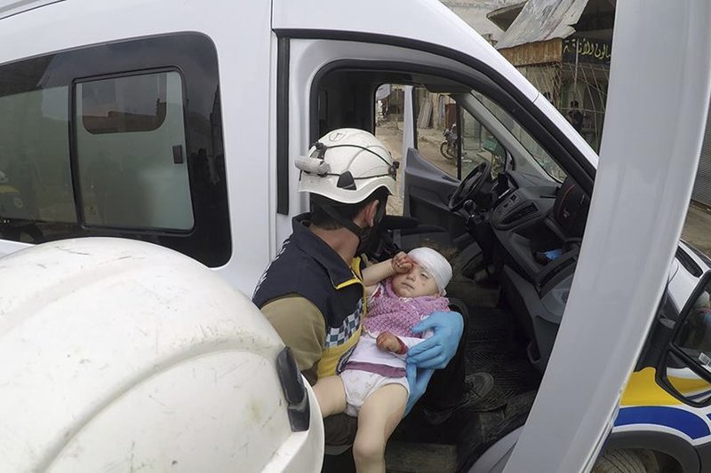This photo provided by the Syrian Civil Defense White Helmets, which has been authenticated based on its contents and other AP reporting, shows a civil defense worker carrying a child after shelling hit a street in the town of Nairab, in the eastern province of Idlib, Syria, Sunday, April 7, 2019. Opposition activists and Syrian state media are reporting at least 13 people have been killed in an exchange of violence between government forces and insurgents in the northwestern part of Syria. (Syrian Civil Defense White Helmets via AP)
