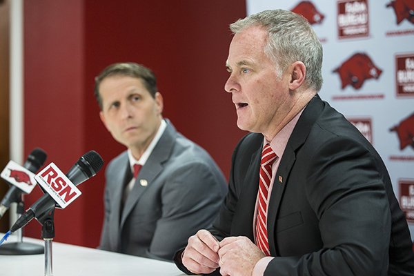 Arkansas athletics director Hunter Yurachek (foreground) answers a question while basketball coach Eric Musselman looks on during a news conference Monday April 8, 2019, in Fayetteville. 