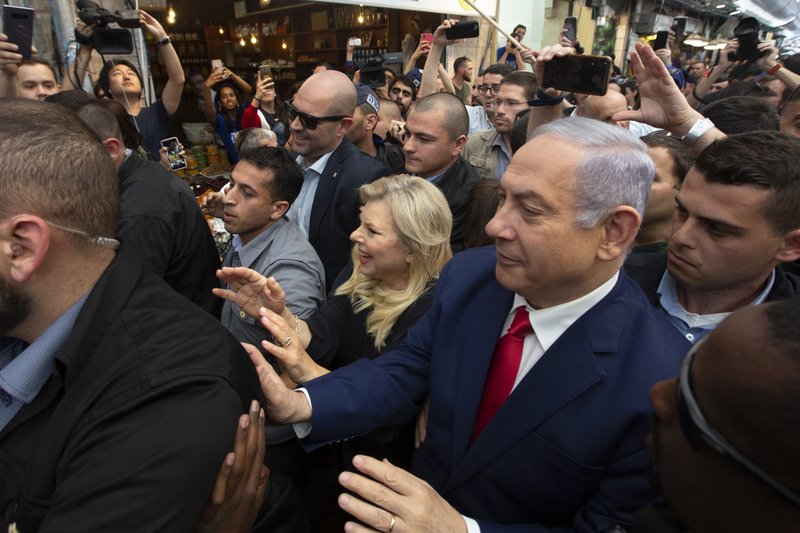 The Associated Press MARKET VISIT: Israeli Prime Minister Benjamin Netanyahu, right, escorted by bodyguards walks with his wife Sara Netanyahu during a visit to the market on the eve of Israel's general elections in Jerusalem, Monday.