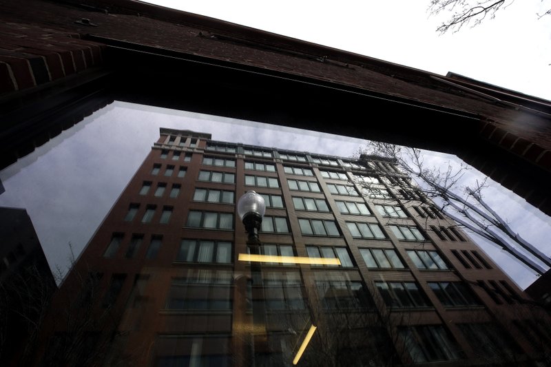 In this March 24, 2019 photo a building is reflected in a window, in Boston. The Labor Department is proposing new rules to determine whether companies can be considered joint employers, sharing control over workers in one of the businesses. (AP Photo/Steven Senne)