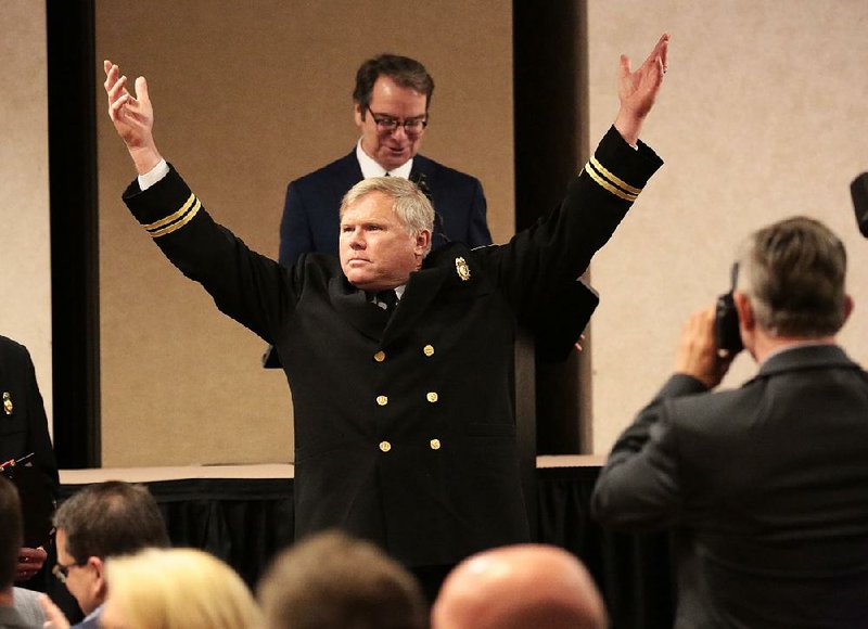 Capt. Edwin Faubion of the North Little Rock Fire Department playfully acknowledges applause after he was named firefighter of the year by the department during a ceremony Tuesday at the Wyndham Riverfront hotel in North Little Rock. Local television personality Bob Clausen (rear) served as emcee at the event.