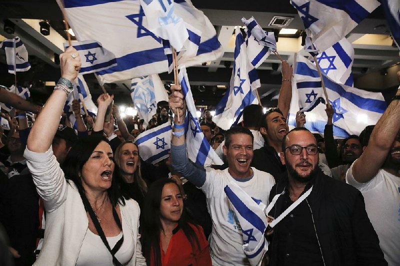 Blue and White part supporters cheer at the party's campaign headquarters after polls for Israel's general elections closed, in Tel Aviv, Tuesday, April 9, 2019. (AP Photo/Sebastian Scheiner)