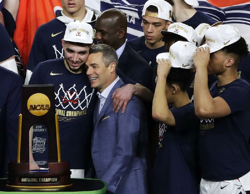 Virginia Coach Tony Bennett (center) celebrates with guard Ty Jerome (left) after the Cavaliers defeated Texas Tech 85-77 to win the national championship Monday night. Bennett’s father, Dick Bennett, reached the Final Four in 2000 with Wisconsin. The Bennetts joined John Thompson and John Thompson III as the only fathers and sons to coach their teams into the Final Four. 