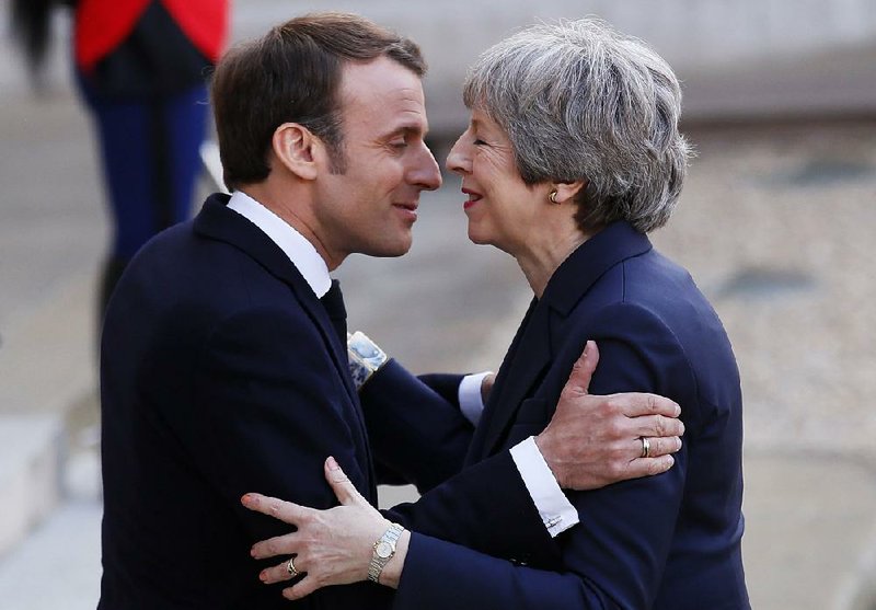 French President Emmanuel Macron greets British Prime Minister  Theresa May before their meeting Tuesday at the Elysee Palace  in Paris during which France softened its position on the timetable  for Britain’s exit from the European Union. 