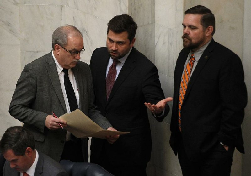 Sen. Kim Hammer (left), R-Benton, talks with Sen. Jonathan Dismang (center), R-Beebe, and Bob Ballinger (right), R-Berryville, during the Senate session on Tuesday, April, 9, 2019, at the State Capitol in Little Rock. 
