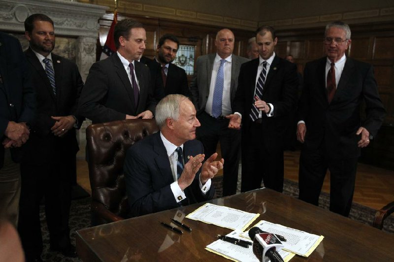 Arkansas Gov. Asa Hutchinson claps after signing tax bills during a signing ceremony on Tuesday, April 9, 2019, at the state Capitol in Little Rock. 