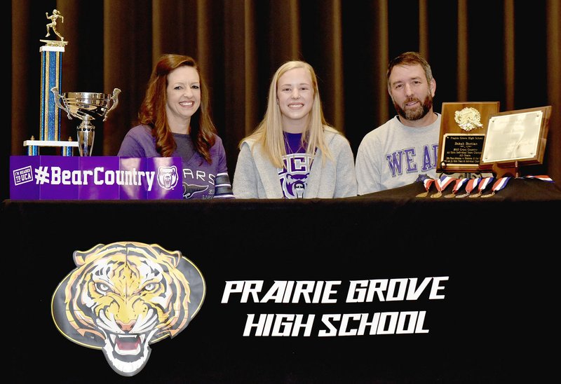Shelley Williams Special to the Enterprise-Leader/Prairie Grove senior Bekah Bostian (center) poses with her parents, Elise and Keith Bostian, while signing a national letter of intent to compete in cross country plus track and field for the University of Central Arkansas in January.