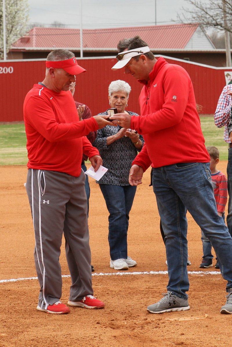 Submitted photo/Farmington head softball coach Randy Osnes (left) receives the National Federation of State High School Associations award for Arkansas Coach of the Year for 2017-2018 (fast pitch) from Farmington athletic director Brad Blew prior to a non-conference game against Vilonia.