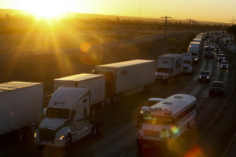 A row of trucks wait to cross the border with the United States in Ciudad Juarez, Mexico, Tuesday, April 9, 2019. The Trump administration has reassigned so many inspectors from U.S.-Mexico border crossings that it has caused huge traffic backups for truckers who are waiting in line for hours and in some case days to get shipments to the U.S. (AP Photo/Christian Torres)