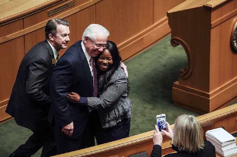 Rep. Carlton Wing (left) squeezes into the frame Wednesday on the House floor as Rep. Jon Eubanks and Rep. Jamie Scott hug and pose for a photo at the close of legislative business. More photos are available at arkansasonline.com/411genassembly/ 