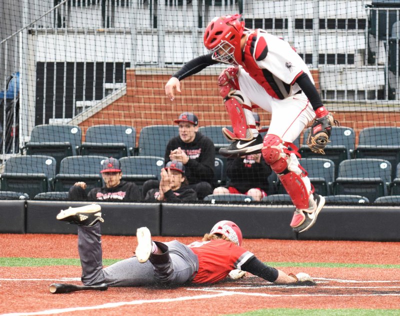 RICK PECK/SPECIAL TO MCDONALD COUNTY PRESS McDonald County catcher Joe Brown dodges a sliding Grove runner during the Ridgerunners' 3-1 win on April 4 in the Mickey Mantle Wood Bat Classic at Joe Becker Stadium in Joplin.