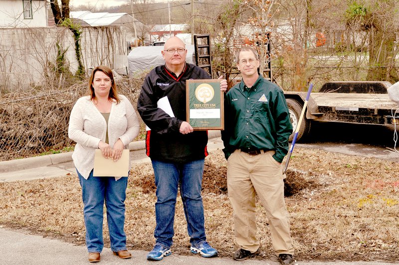 RACHEL DICKERSON/MCDONALD COUNTY PRESS Jon Skinner of the Missouri Department of Conservation (right) presents Pineville Mayor Greg Sweeten and Angela Cawood of the Pineville Tree Board with an award for being a Tree City USA during the city's Arbor Day celebration April 4.