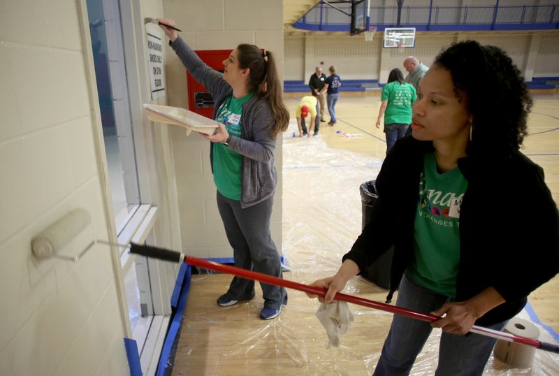 FILE PHOTO/DAVID GOTTSCHALK Michelle Wilson (right) uses a roller as Molly White, volunteers with Pinnacle Foods Inc., uses a brush to apply paint to the gym walls at the Donald W. Reynolds Boys &amp; Girls Club in Fayetteville during the 2018 United Way of Northwest Arkansas Live United Day. Some 430 volunteers in Northwest Arkansas will help area nonprofit organizations for the one day of service April 26.