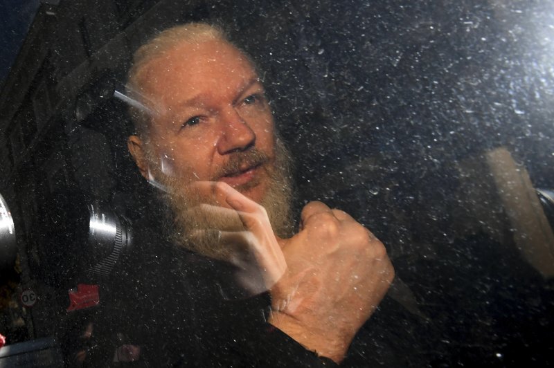 Julian Assange gestures as he arrives at Westminster Magistrates' Court in London, after the WikiLeaks founder was arrested by officers from the Metropolitan Police and taken into custody Thursday April 11, 2019. Police in London arrested WikiLeaks founder Assange at the Ecuadorean embassy Thursday, April 11, 2019 for failing to surrender to the court in 2012, shortly after the South American nation revoked his asylum .(Victoria Jones/PA via AP)

