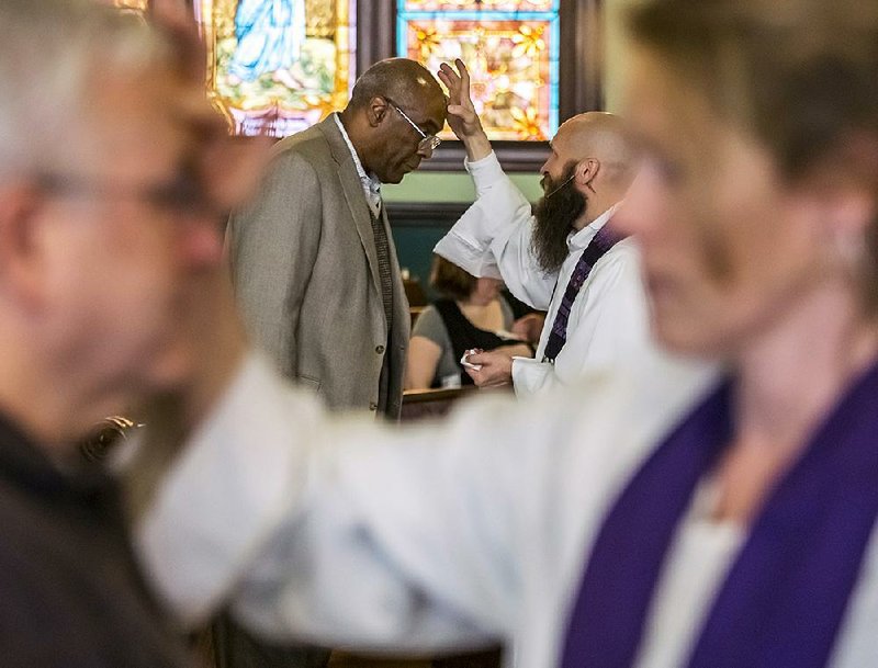 The Revs. David Freeman (background right), senior pastor, and Donna Hankins-Hull, associate pastor (foreground right), apply the mark of the cross to churchgoers at a 2017 Ash Wednesday service at Little Rock’s First United Methodist Church. Lent lasts 40 days, during which time the faithful give up something they enjoy as a sacrifice. 