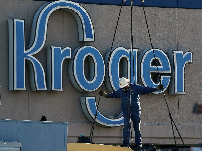 Workers hook up cables while replacing the air conditioners at a Kroger store in North Little Rock in 2017. 