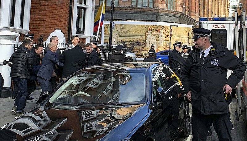 Police carry Julian Assange (view obscured) out of Ecuador’s Embassy in London on Thursday. The WikiLeaks founder had taken refuge at the embassy in 2012 while facing extradition to Sweden on sexual assault allegations that have since been dropped. 