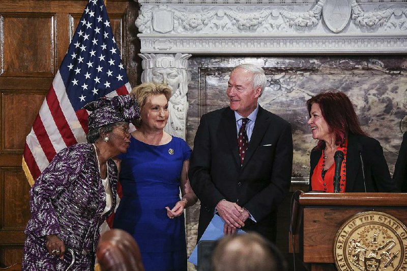 Annie Abrams (left) is introduced to Rosanne Cash, daughter of the late musician Johnny Cash, by Gov. Asa Hutchinson and Arkansas first lady Susan Hutchinson during a bill-signing ceremony Thursday at the Capitol.