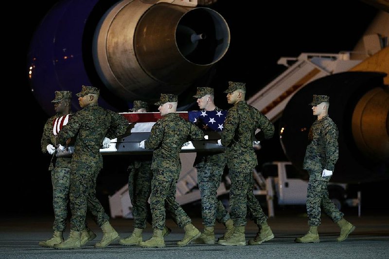 A U.S. Marine Corps carry team moves a transfer case containing the remains of Staff Sgt. Christopher Slutman, on Thursday, at Dover Air Force Base, Del. According to the Department of Defense, Slutman, of Newark, Del., was among three American service members killed by a roadside bomb on Monday, near Bagram Airfield in Afghanistan. 