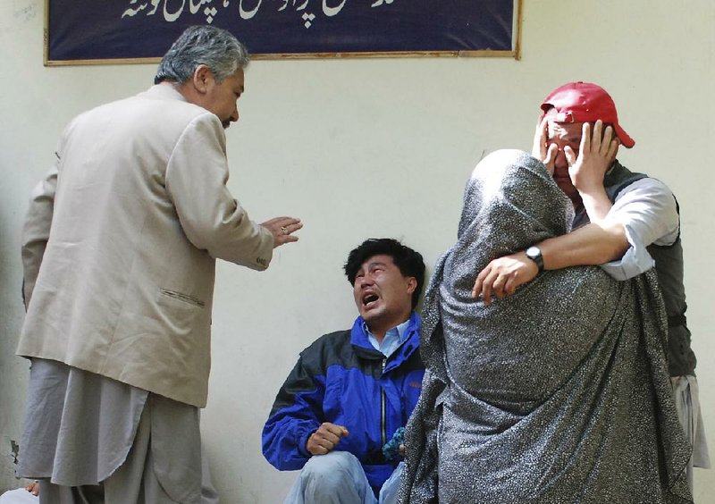 Family members of blast victims comfort each other outside a mortuary in Quetta, Pakistan, on Friday. 