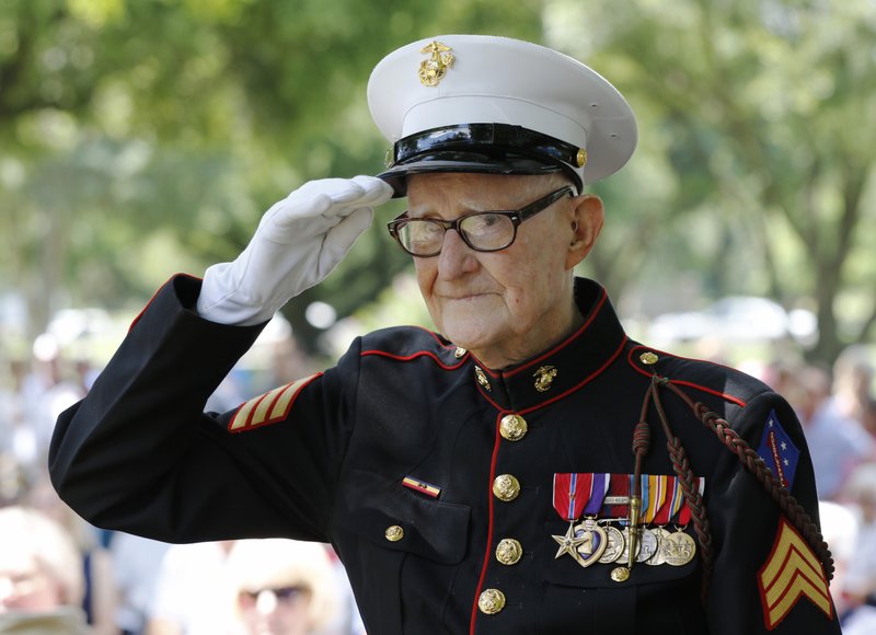 In a May 30, 2016 photo, U.S. Marine veteran R. V. Burgin, 93, salutes during the 76th Annual Memorial Day Service at Restland Memorial Park in Dallas. Burgin, whose book about grueling jungle combat during WWII became a basis for the HBO miniseries &quot;The Pacific&quot; died April 6, 2019 at his home in Texas. He was 96. (David Woo/The Dallas Morning News via AP)