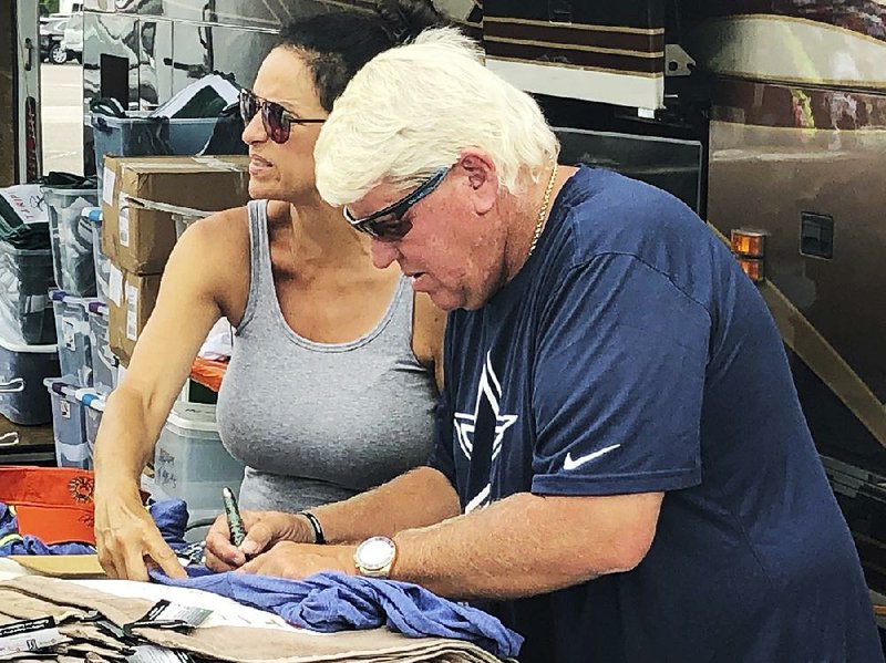 John Daly signs autographs outside a Hooters on Washington Road during the third round of the Masters on Saturday in Augusta, Ga. 