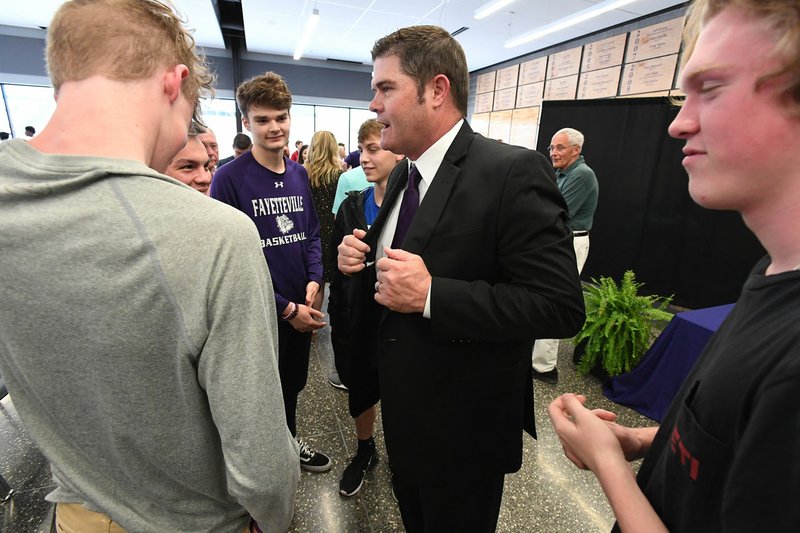 NWA Democrat-Gazette/J.T. WAMPLER Brad Stamps (center) talks with Fayetteville basketball players after being named head coach of the Bulldogs. Stamps replaces Kyle Adams, who is retiring after 37 years as a coach.