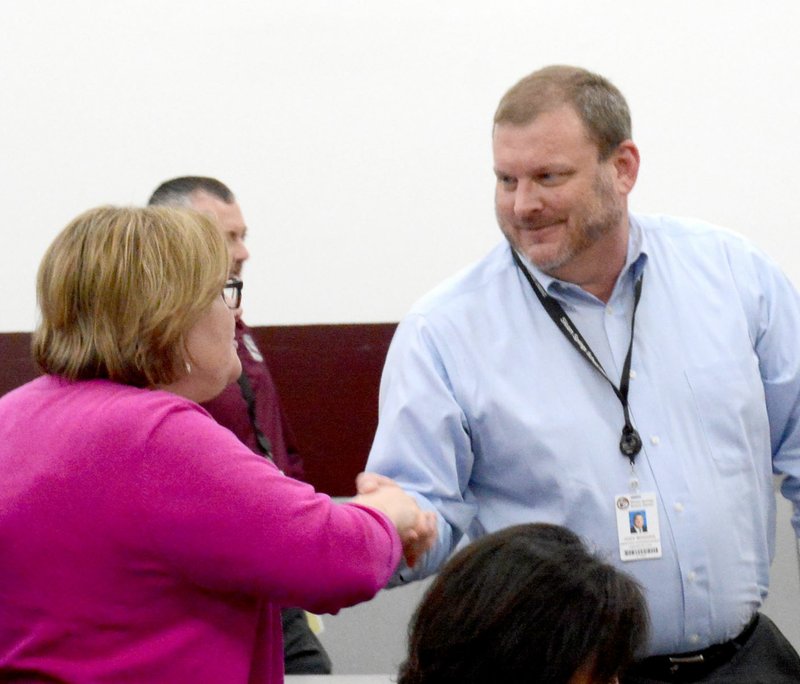 Janelle Jessen/Herald-Leader Assistant Superintendent Jody Wiggins, right, shook hands with Charlotte Earwood, director of school improvement and student services, after the school board meeting on Thursday where Wiggins was named superintendent. Earwood was one of many school board members and administrators to congratulate Wiggins. He will transition into the new role on July 1.