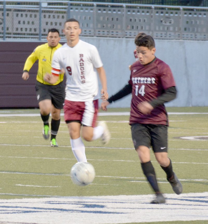 Graham Thomas/Siloam Sunday Siloam Springs midfielder Julio Maldonado dribbles the ball as Beebe's Daniel Martinez gives chase during Friday's game at Panther Stadium.