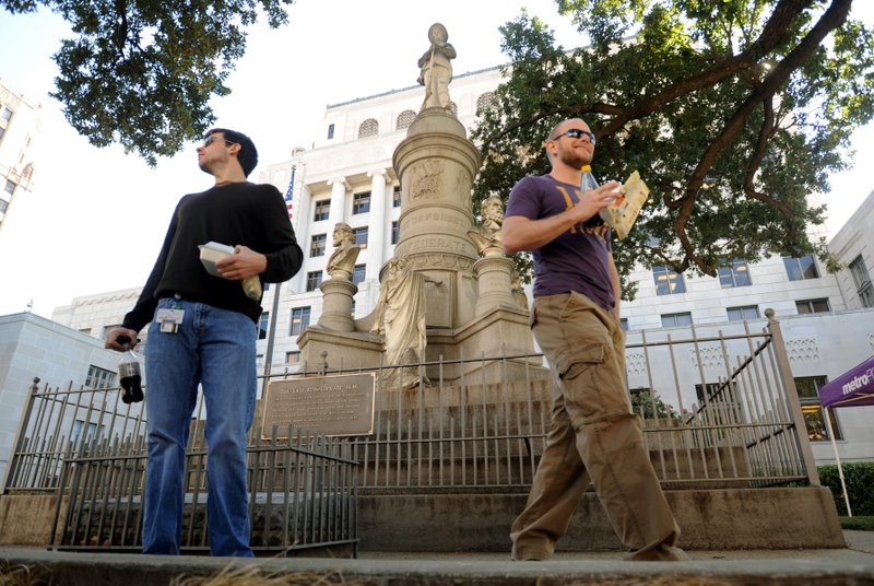 FILE - In this Nov. 4, 2011, file photo, Sean Bordelon, left, and Raphiel Heard, of Shreveport, pause after reading the inscription on the Confederate soldier's monument in front of the Caddo Parish Courthouse in Shreveport, La. A federal appeals court says a judge was right when he cleared the way to remove a Confederate monument at a north Louisiana courthouse. The 5th U.S. Circuit Court of Appeals on Monday, April 15, 2019, again turned back claims from the United Daughters of the Confederacy’s Shreveport chapter. The group says it has a “private property interest” in the land where the statue stands in front of the Caddo Parish Courthouse. It also claims parish officials violated its rights to free speech and equal protection. (Douglas Collier/The Shreveport Times via AP, File)