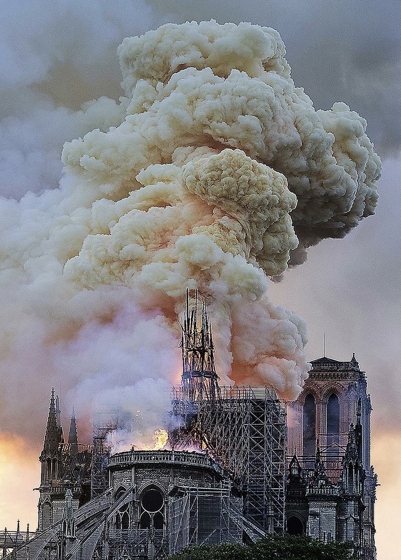 Flames and smoke rise as the spire on Notre Dame Cathedral collapses Monday in Paris.