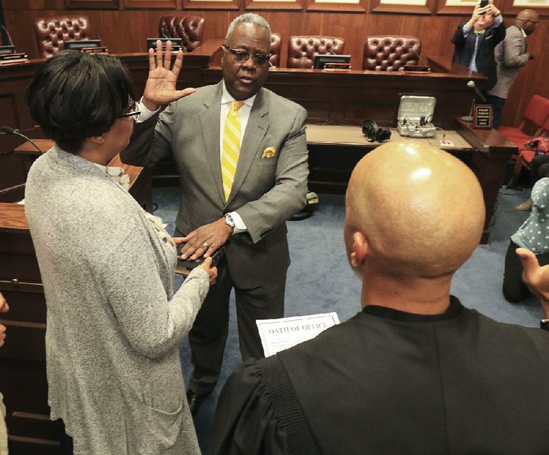 New Little Rock Police Chief Keith Humphrey (center) is joined by his wife, Pamela, as he is sworn in Monday at City Hall by Little Rock District Judge Mark Leverett.