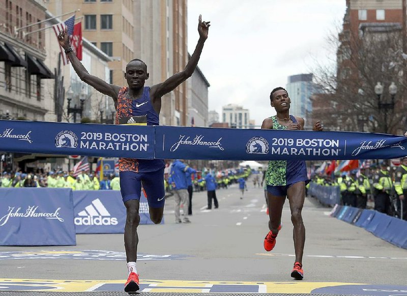 Lawrence Cherono of Kenya crosses the finish line to win the men’s race of the 123rd Boston Marathon in front of Lelisa Desisa of Ethiopia (right) on Monday in Boston. It was the first major marathon victory for Cherono, who finished in 2:07:57.