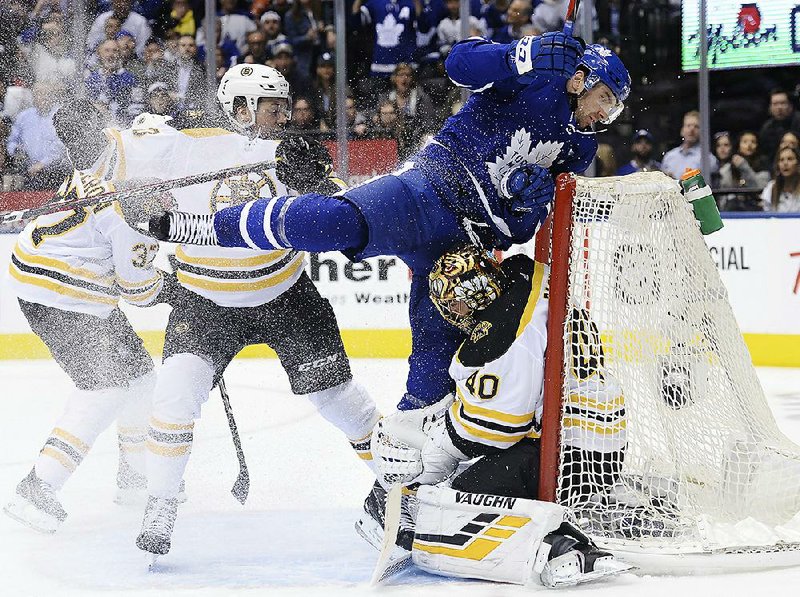 Toronto Maple Leafs center John Tavares (center) runs into Boston Bruins goaltender Tuukka Rask during the second period Monday in Toronto. The Maple Leafs won 3-2 to take a 2-1 series lead.