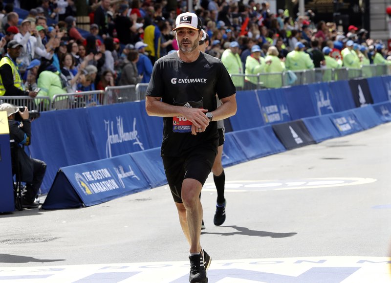 NASCAR driver Jimmie Johnson, of Charlotte, N.C., finishes the 123rd Boston Marathon on Monday, April 15, 2019, in Boston. (AP Photo/Winslow Townson)