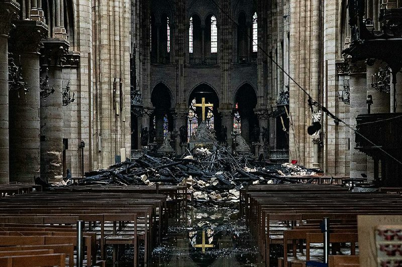 Burned wood and damaged stone sit on the watery floor of Notre Dame Cathedral on Tuesday. One expert said it could take “years, perhaps even decades” to rebuild the Paris landmark. 