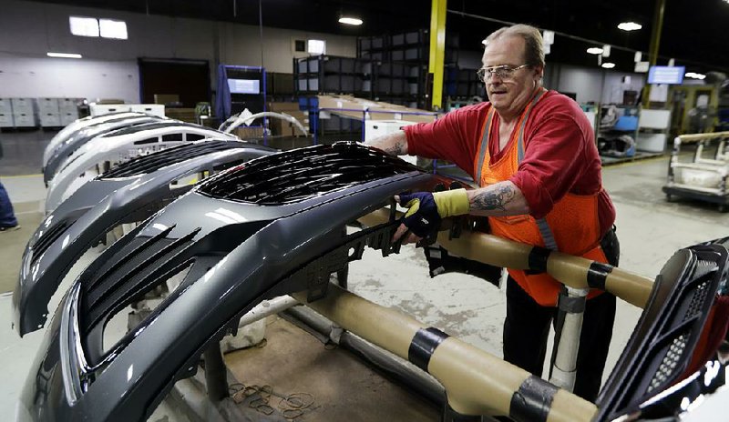 Clifford Goff moves a front-end component of a Chevrolet Cruze during assembly last fall at Jamestown Industries in Youngstown, Ohio. Production of cars, trucks and auto parts dropped 2.5 percent in March and 4.5 percent over the past year. 