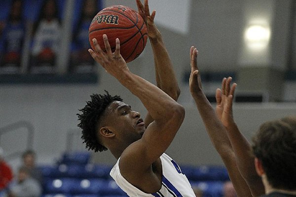 Conway's Caleb London (1) puts up a shot over Cabot defenders during the fourth quarter of Conway's 47-45 win on Friday, Feb. 8, 2019, at Buzz Bolding Arena in Conway. 