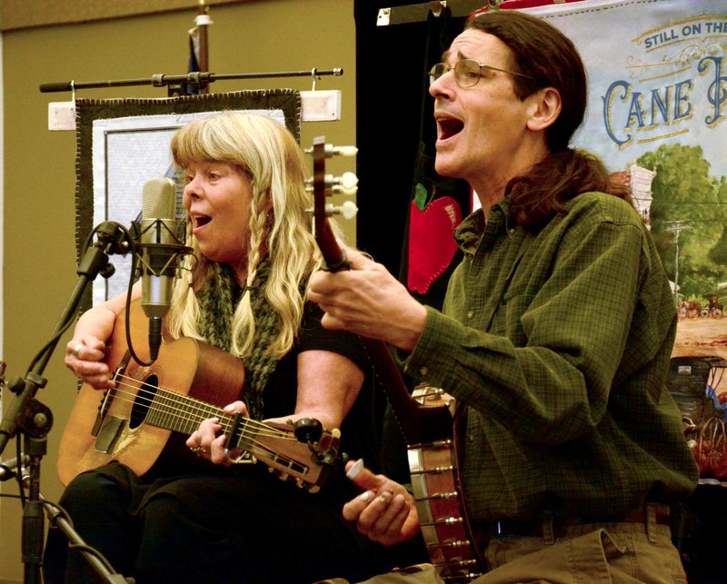 JANELLE JESSEN ENTERPRISE-LEADER Donna (left) and Kelly Mulhollan of Still on the Hill performed their final concert about the history of Cane Hill at the Siloam Springs Public Library in late March. The couple was commissioned to write songs about Historic Cane Hill and perform them at a series of 13 free concerts.