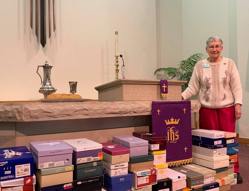 Photo submitted Burnis Leavens, Shoebox Ministry Leader, stands next to 50 shoeboxes that were dedicated during the March 24 worship service at the Presbyterian Church of Bella Vista.