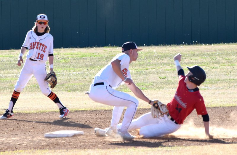 Westside Eagle Observer/MIKE ECKELS With Keegan Bulza (19) as backup, Lion's Hunter Cole (center) tags out a Blackhawk runner at second base during the April 8 Gravette-Pea Ridge baseball contest at Lion Ball Field in Gravette.