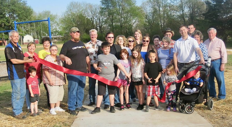 Westside Eagle Observer/SUSAN HOLLAND Several area residents smile for the camera just after the ribbon cutting at the Hiwasse Park walking and bike trail Tuesday evening, April 9. Mayor Kurt Maddox and his wife Dawn were joined for the official opening of the trail by members of the Greater Gravette Chamber of Commerce, a city council member, Hiwasse residents and the engineer and contractor on the project.