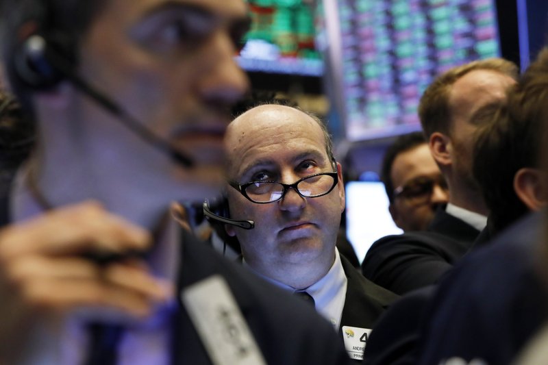  In this April 12, 2019, file photo trader Andrew Silverman, center, works on the floor of the New York Stock Exchange.  (AP Photo/Richard Drew, File)