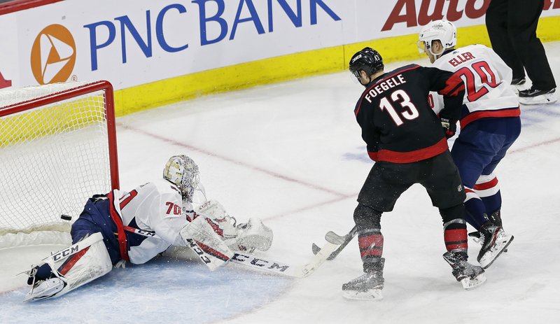 The Associated Press BREEZY GOAL: Carolina Hurricanes' Warren Foegele (13) scores against Washington Capitals goalie Braden Holtby (70) while Capitals' Lars Eller (20) defends during the second period of Monday's playoff game in Raleigh, N.C.