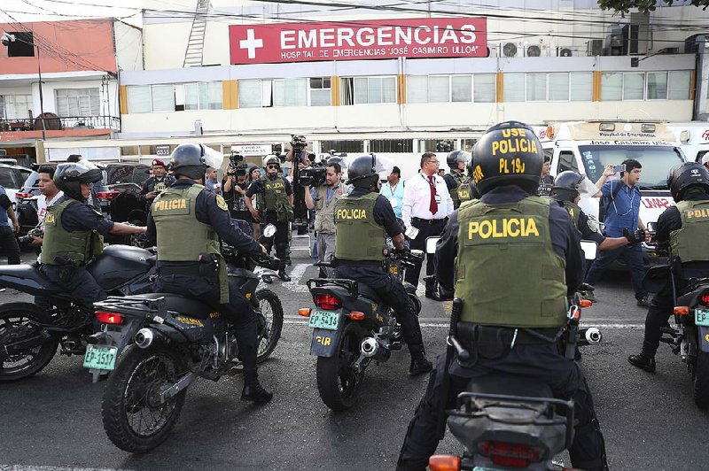 Police in Lima, Peru, stand guard Wednesday outside the emergency entrance of the Casimiro Ulloa hospital where former President Alan Garcia was taken after he shot himself. 