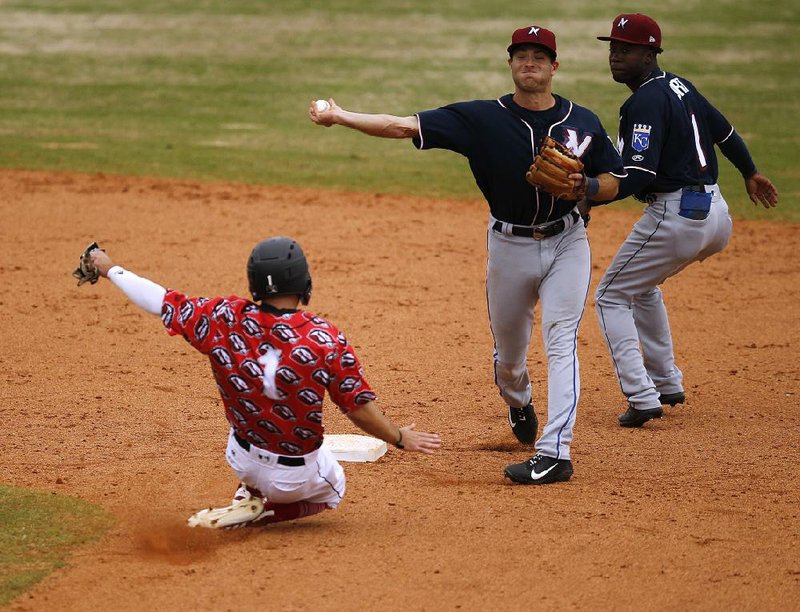 Arkansas Democrat-Gazette/THOMAS METTHE -- 4/13/2019 --
Northwest Arkansas Naturals shortstop Taylor Featherston (12) tries to turn a double play after getting out Arkansas Travelers baserunner Aaron Knapp (1) during the bottom of the eighth inning of the Travelers' 2-1 loss on Wednesday, April 17, 2019, at Dickey-Stephens Park in North Little Rock. 