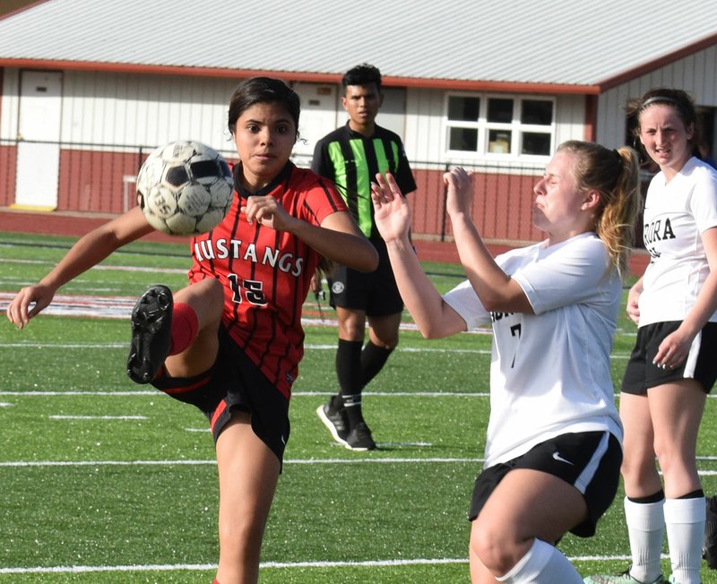 RICK PECK/SPECIAL TO MCDONALD COUNTY PRESS McDonald County's Helen Reyes tries to get past an Aurora defender during the Lady Mustangs' 2-1 loss in a shoot out on April 9 at MCHS.
