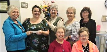 Submitted photo VAC DONATION: Standing, from left, are Village Art Center President Cindy Ridgway and McAuley Director Kelly Chacon, who are joined by members Vicki Patterson, Barbara Harrison and Sue Hoyt, and, seated, Judy Robbins and Carol Patterson.