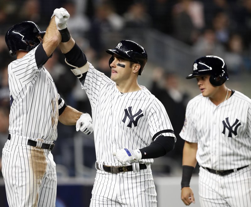 The Associated Press THREE-RUN SHOT: New York Yankees' Brett Gardner, left celebrates with the Mike Tauchman after Tauchman hit a three-run home run off Boston Red Sox's Erasmo Ramirez in the sixth inning of Tuesday's game in New York. Yankees' Gio Urshela, right, scored on the homer, as did Gardner.